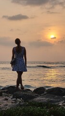 a girl watching the sunset by the sea