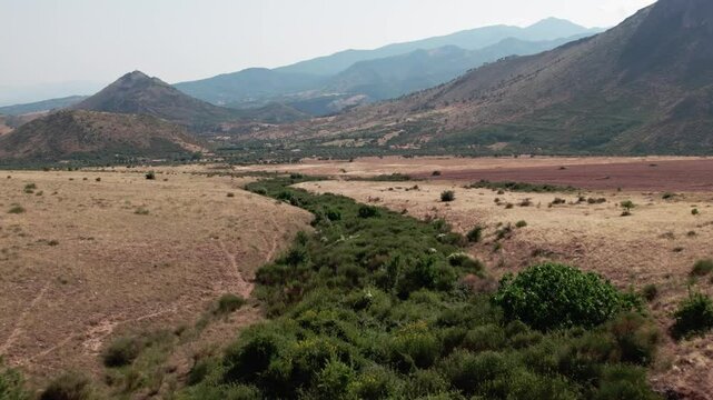A drone over fields and mountains near Sibari, Italy. A cloudy summer day