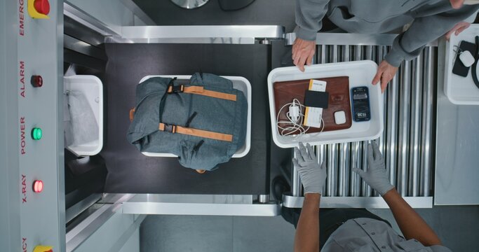 Top View on Diverse People, Passengers Putting Personal Items in Plastic Trays for Screening Procedures in X-ray Scanning Conveyor Belt. TSA Airport Security Checkpoint before Boarding Plane Flight.