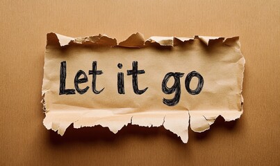The words Let it go emerging from distressed brown paper.
