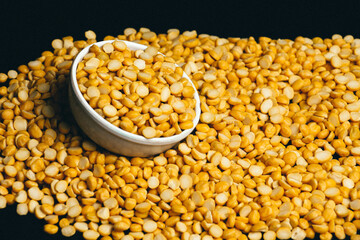 Close-up organic Bengal gram (Cicer arietinum) or split yellow chana dal background. Top view. Channa dal, famous Indian legume also called yellow Pigeon peas.