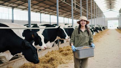 Smiling Dairy Farmer Feeding Cows in a Modern Cattle Barn