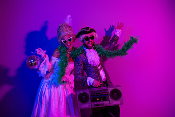 Dressed in historic costumes, a lively couple celebrates in a colorful neon-themed party setup,...