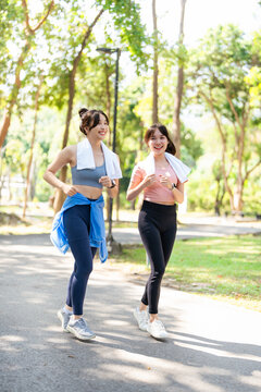 Exercise concept. young women are running inside the park. Beautiful Asian girls like to exercise in the park.