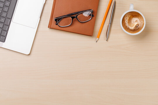 A clean and minimal desk setup featuring a laptop and a coffee cup