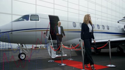 Exiting private jet, business professionals with stock market graph animation overlay - Powered by Adobe