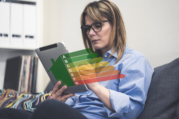 Home energy rating. Woman reviews energy efficiency on tablet. Home improvement & performance evaluation