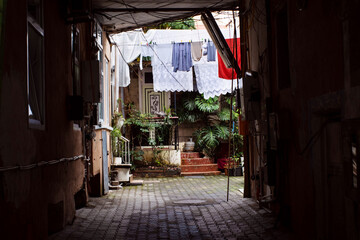Georgian old house yard through an arch, lots of wires, clothes and linen drying on ropes. Batumi, Georgia