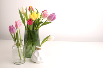 White spring tulips in a vase on a white table. Mock up for displaying works