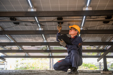Solar panel installer is inspecting the electrical circuits and wiring connected to the solar panels.