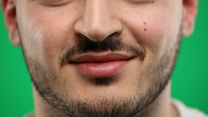 Obraz premium Man's mouth, close-up, on a green background