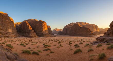Naklejka premium Panoramic view of Wadi Rum desert at sunset with rocky formations and sparse vegetation
