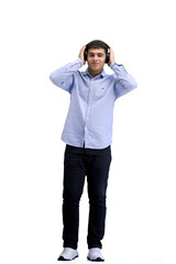 Fototapeta premium A man, full-length, on a white background, listening to music with headphones