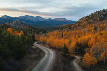 Scenic Winding Road Through Autumn Valley at Sunset with Golden Light


