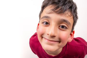 Happy child smiling boy wearing casual red sweater standing on isolated white background. Happy, cool and fun smile on face, kid looking at camera. Close up portrait