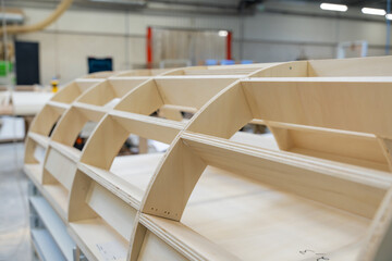 Focus sur la fabrication de meubles en bois dans un atelier de menuiserie, créés sur mesure pour un hôtel haut de gamme, mettant en valeur le savoir-faire artisanal et les matériaux de qualité.