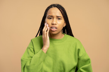 Young woman having a toothache and touching her cheek