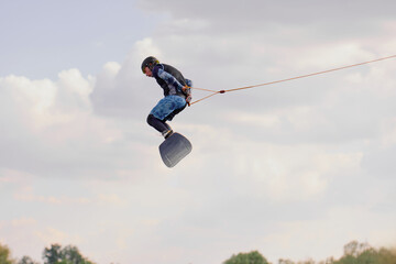 Wakeboarder in mid-air trick against cloudy sky