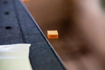 Gros plan de la découpe de miroir sur mesure en atelier, mettant en valeur le travail précis et la technique artisanale.