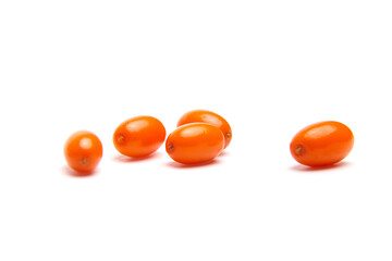 Scattered sea buckthorn berries with a vibrant orange color against a white background. The small, oval berries have a smooth, glossy surface and appear fresh