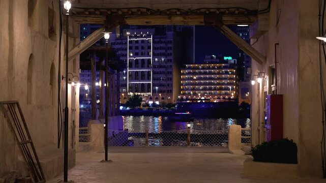 Dubai in night time.  View of the Dubai Creek. Boat staying on river in night time in Dubai Creek. Bright lights illuminate the boat.   Deira old town in United Arab Emirates. 