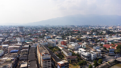 Fototapeta premium Chiang Mai cityscape expanding towards Doi Suthep mountain range under polluted sky