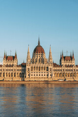 Obraz premium hungarian parliament building front view at sunset golden hour with water danube reflections in water