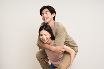 Piggyback ride Happy asian couple attractive in various action gesture standing on isolated white background. Cheerful Smiling young man and woman fun with piggyback ride