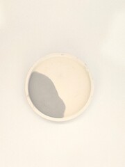 A small modern cylindrical concrete planter with a black and white marbled pattern, placed on a plain background.