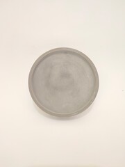Plain gray concrete plant saucer with a simple and smooth finish.