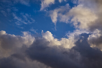 Sun rays break through a mass of heavy clouds, creating golden highlights on their edges. A magical sky scene full of dramatic light interplay.