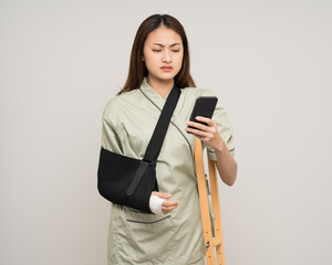 Depressed upset woman suffering from pain. Broken arm. Asian woman put on plaster bandage cast...
