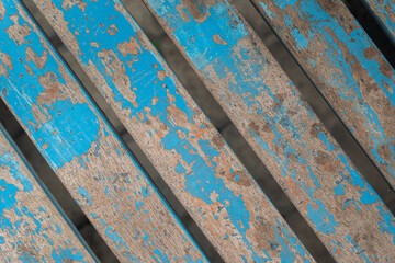 Blue wooden planks, worn wooden surface of kitchen table. Faded wooden color of wooden chairs.