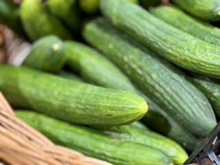 A lot of green cucumbers in a market counter for sale on sale in vegetable stand display at supermarket show organic food, vegetarian food, healthy food. Close-up