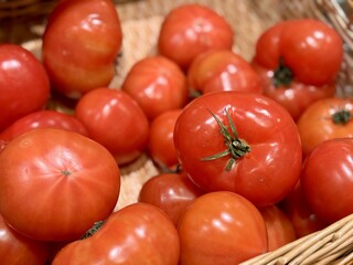 Fresh red tomatoes in container baskets, offered for sale at the supermarket's vegetable stand, showcase organic, vegetarian and healthy food. Close-up