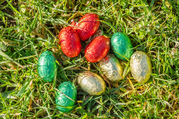 Colorfully painted easter eggs on the grass on a sunny day.