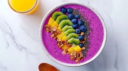 there is a bowl of fruit and a spoon on a table
