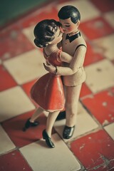 there is a figurine of a man and a woman on a checkered floor