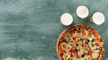 Delicious italian pizza with beer on the table, top view