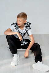 a teenage boy with a skateboard, a child boy on a white background, a space and a place for text, a child playing sports