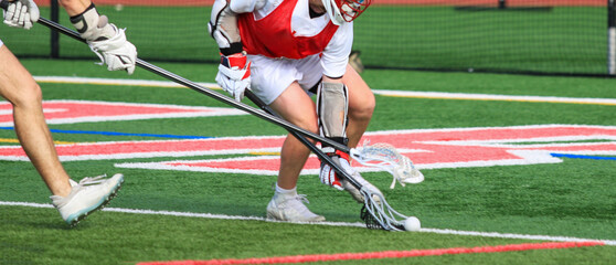 Lacrosse Players Compete for Possession on a Match on a Turf Field