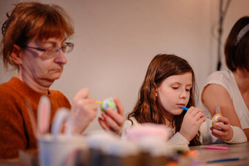 Grandmother and Granddaughter Painting Easter Decorations
