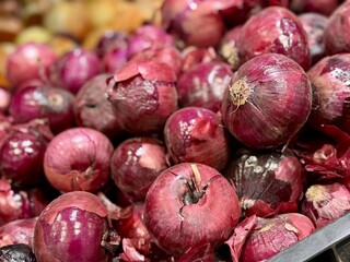  Pile of an large red onion sale in box in vegetable stand display at supermarket show organic food, vegetarian food, healthy food. Close-up