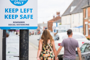Keep left, keep safe, One way system and social distancing sign displayed on street of Southwold in...