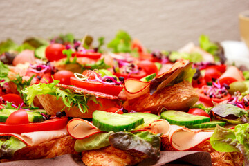 A vibrant array of sandwiches is adorned with fresh vegetables such as cucumber slices,cherry tomatoes and leafy greens.The crunchy texture of the bread contrasts with the colorful and fresh toppings.