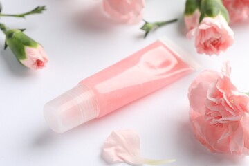 Lip balm and eustoma flowers on white background, closeup