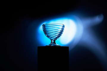 Glass Goblet with Spiral Design against Blue Light on Black Background