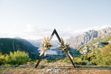 Wedding teepee arch stands on the mountain above the Kotor Bay valley. Montenegro © VolodymyrNadtochii