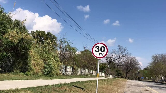 traffic sign for 30 kilometer per hour speed limit, 30 km speed limit sign. , Road sign board with speed limit 30 LTV written on it with trees in background 
