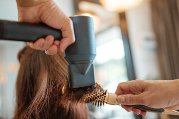Close-up Hairdresser drying clients hair working with professional tools in beauty salon or barber...